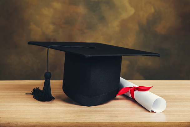 Graduation concept.graduation cap, hat with degree paper on wood - Photo, image