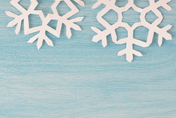 origami paper snowflakes on blue wooden table surface, top view  - Photo, image