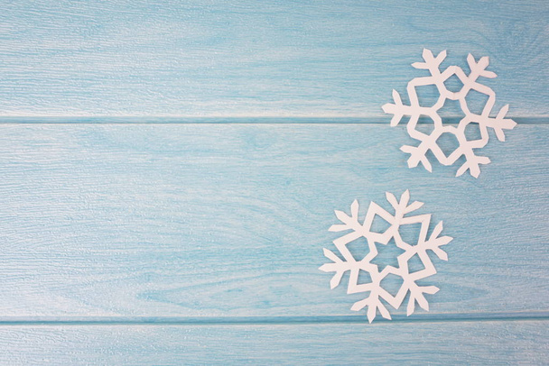 Origami papieru płatki śniegu na niebieskim drewnianej powierzchni stołu, widok z góry  - Zdjęcie, obraz