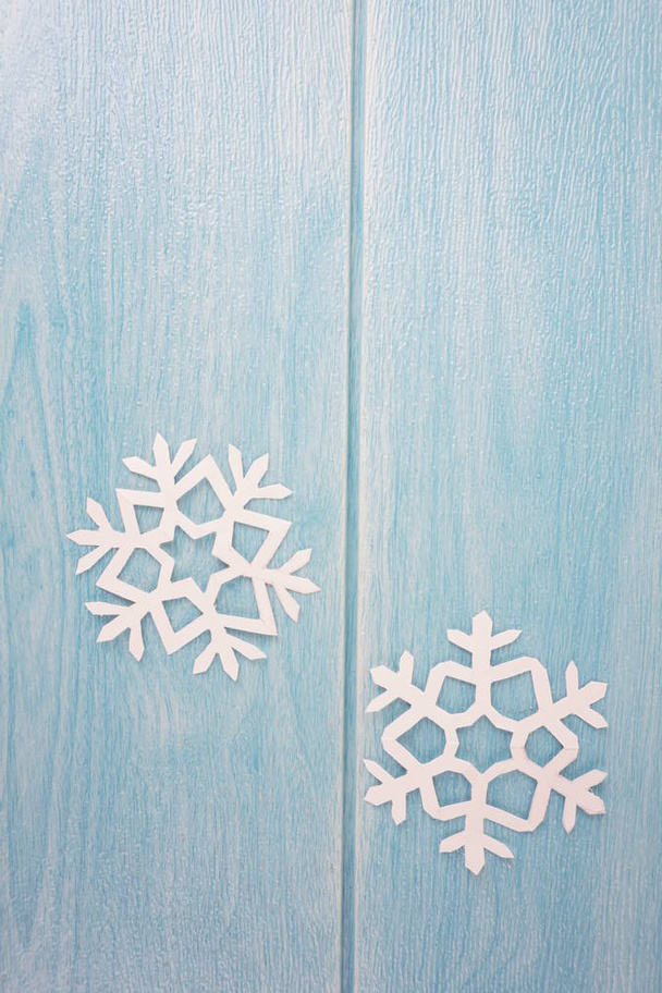 Origami papír hópelyhek a kék fából készült asztal felülete, felülnézet  - Fotó, kép