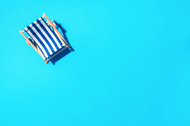 Flat lay of beach deck chair on blue background with copy space. Summer and travel concept. Creative banner - Fotografie, Obrázek