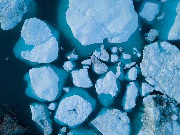Icebergs drone antenne beeld bovenaanzicht-klimaatverandering en opwarming van de aarde. Ijsbergen van de smelt gletsjer in icefjord in Ilulissat, Groenland. Arctische natuur Ijslandschap in UNESCO World Heritage site - Foto, afbeelding