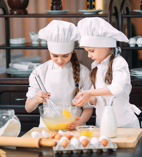 zábavné dívky děti připravují těsto v kuchyni. - Fotografie, Obrázek
