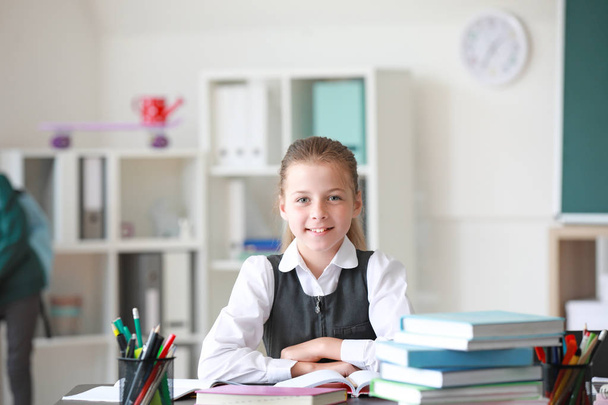 Cute little schoolgirl in classroom - Valokuva, kuva