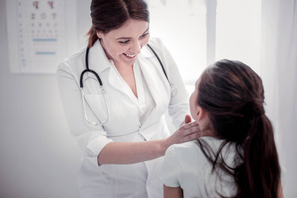 Zadowolona kobieta pediatra patrząc na jej pacjenta - Zdjęcie, obraz