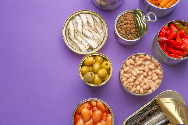 Latas de lata com alimentos diferentes no fundo de cor
 - Foto, Imagem