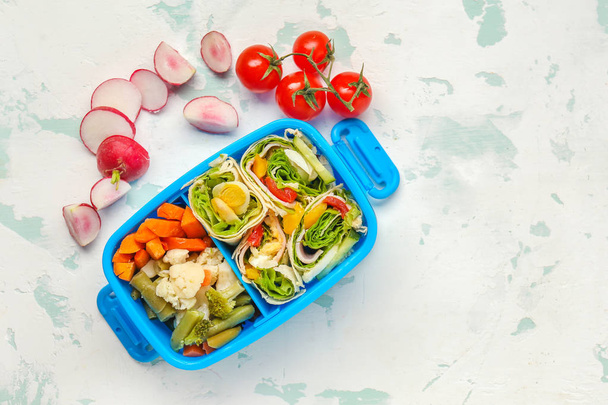School lunch box with tasty food on light background - Photo, Image