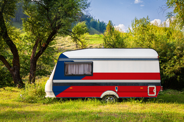 A car trailer, a motor home, painted in the national flag of  Czech stands parked in a mountainous. The concept of road transport, trade, export and import between countries. Travel by car - Photo, Image