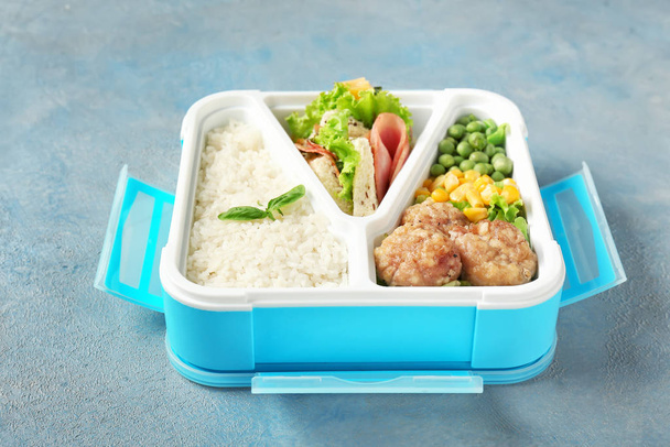 Σχολικό κουτί μεσημεριανού γεύματος με νόστιμο φαγητό στο φόντο του χρώματος - Φωτογραφία, εικόνα