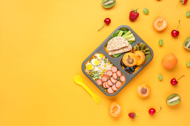 School lunch box with tasty food on color background - Foto, Imagen
