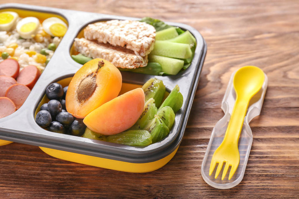 Шкільна обідня коробка зі смачною їжею на дерев'яному столі
 - Фото, зображення