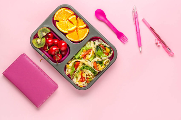 Almuerzo escolar con comida sabrosa y papelería sobre fondo de color
 - Foto, Imagen