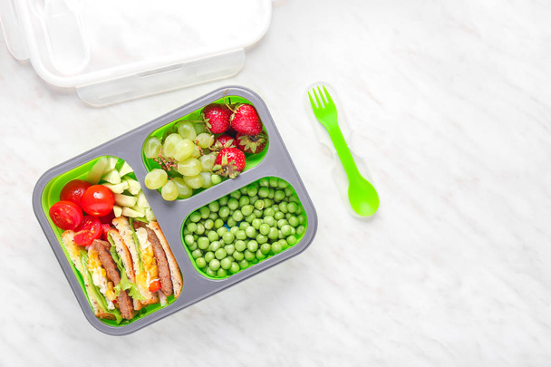 Almuerzo escolar con comida sabrosa sobre fondo claro
 - Foto, Imagen