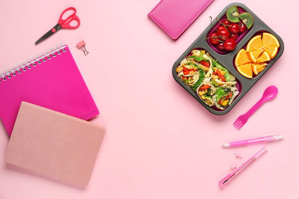 Boîte à lunch scolaire avec une nourriture savoureuse et de la papeterie sur fond de couleur
 - Photo, image