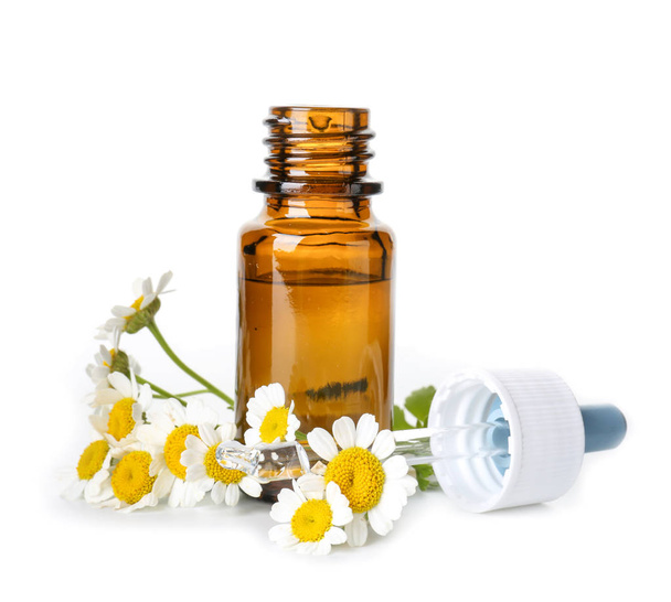 Bottle of essential oil with chamomile flowers on white background - Photo, Image