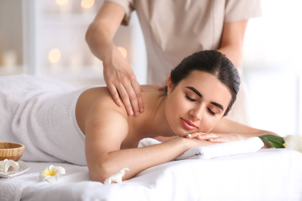 Beautiful young woman receiving massage in spa salon - Фото, зображення