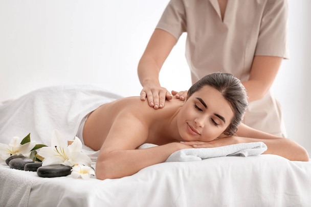 Красивая молодая женщина получает массаж в спа-салоне - Фото, изображение