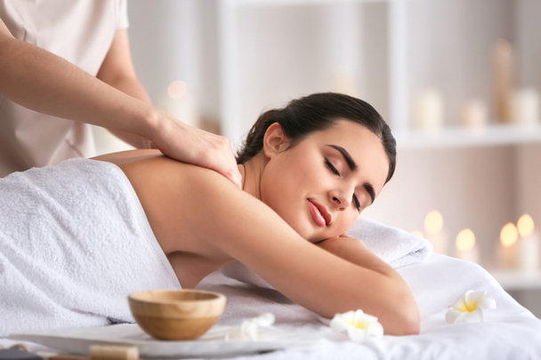 Beautiful young woman receiving massage in spa salon - Foto, imagen