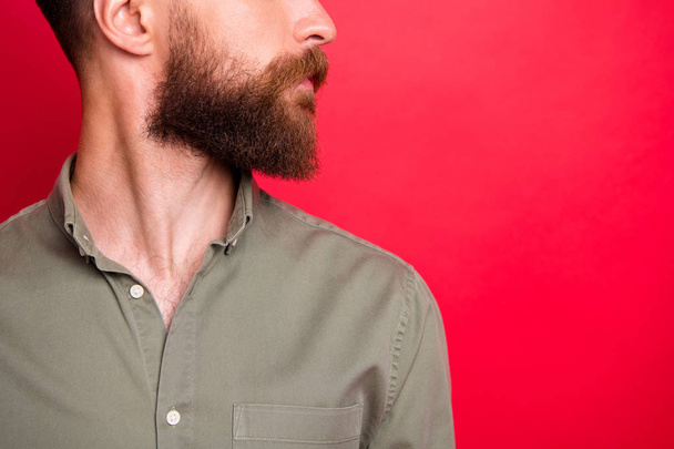 Close up cropped photo of bearded man caring about his facial skin well while isolated with red background - 写真・画像