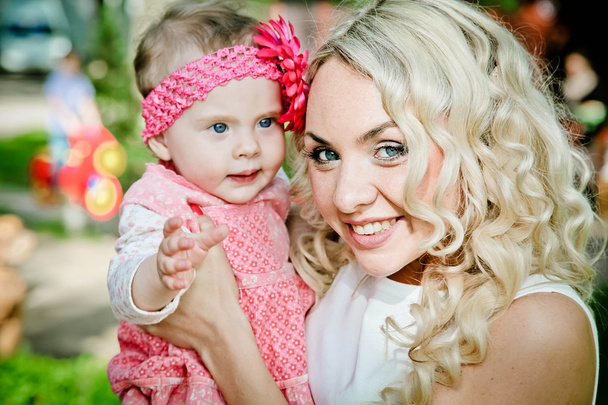Porträt einer lächelnden schönen jungen Frau und ihrer kleinen Tochter - Foto, Bild