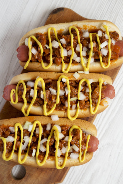 Homemade detroit style chili dog on a rustic wooden board on a w - Fotoğraf, Görsel