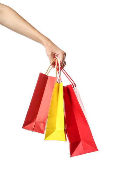 Female hand with shopping bags on white background - Foto, afbeelding