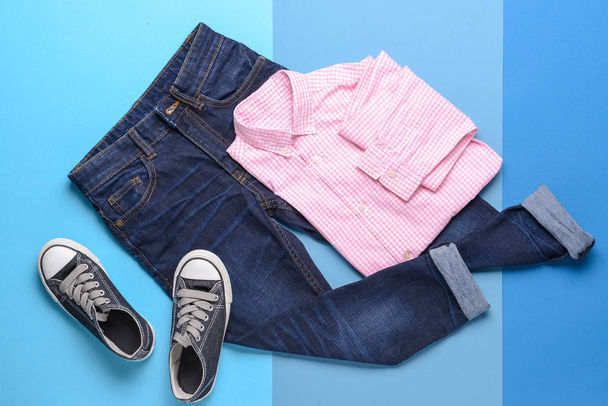 Elegantní dítě vzhled džínů s oblečením na barevné pozadí - Fotografie, Obrázek