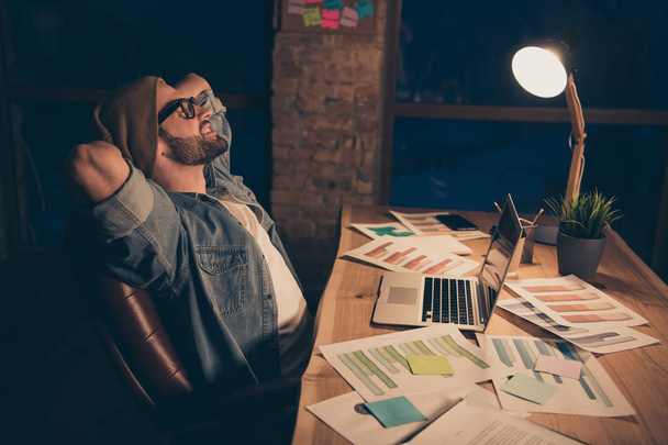 Profile photo of relaxing guy work at dark time having some rest wear casual outfit sit modern office - 写真・画像