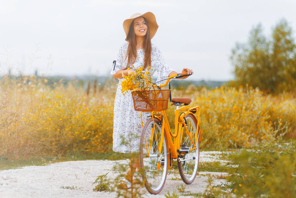 屋外でレトロな自転車で美しいスタイリッシュな女性のフルボディポートレート  - 写真・画像