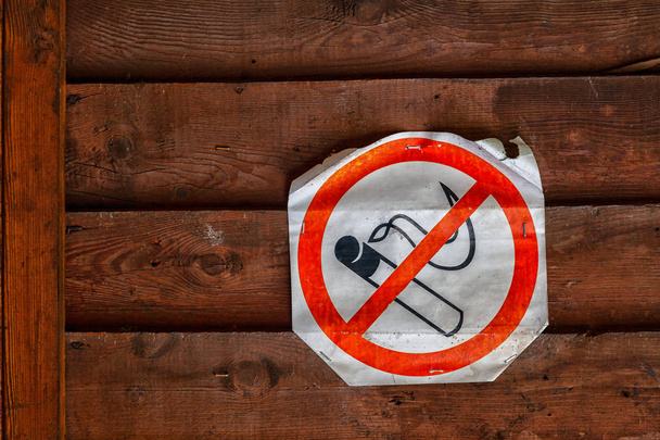 Primer plano de un cartel de prohibición de fumar en la pared de madera marrón. El concepto de prohibición y abandono del tabaquismo
 - Foto, Imagen
