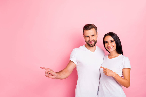 Portrait of his he her she two nice attractive lovely charming content cheerful cheery spouses pointing forefingers aside ad isolated over pink pastel background - Fotó, kép