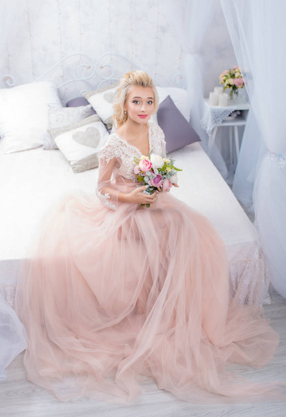 Nevěsta ve svatebních šatech ve studiu s bílou výzdobou - Fotografie, Obrázek