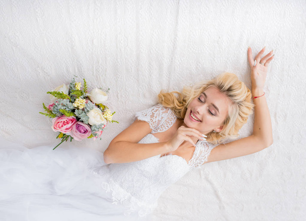 Bride in a wedding dress in the studio on white background - Foto, imagen
