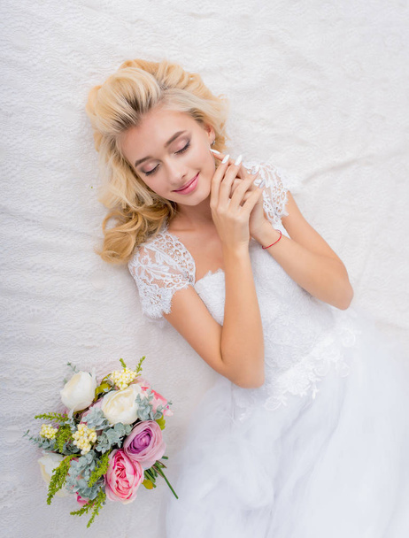 Schönheit Braut im Brautkleid posiert mit Strauß in den Händen - Foto, Bild