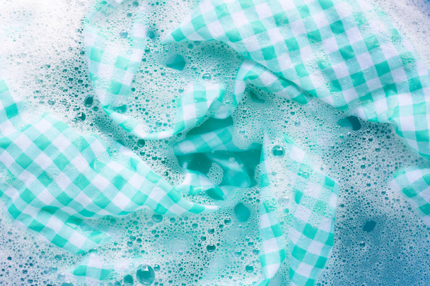 Tovaglia bianca verde immersa nel detergente in polvere acqua dissolutio
 - Foto, immagini