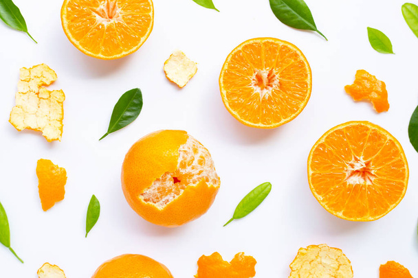 白い背景に緑の葉とオレンジの果物の組成物 - 写真・画像