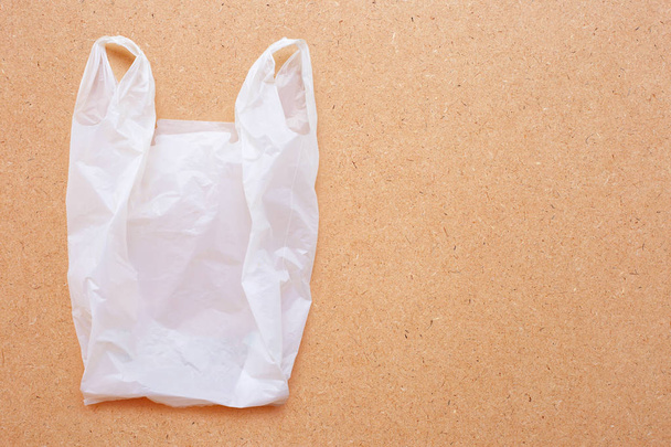 White plastic bag on wooden background. - Foto, afbeelding
