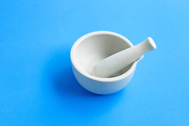 Mortar and pestle on blue background.  - Photo, Image