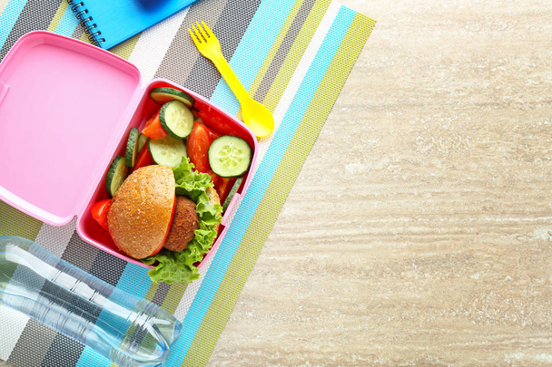 Caixa de almoço escolar com comida saborosa na mesa de madeira
 - Foto, Imagem