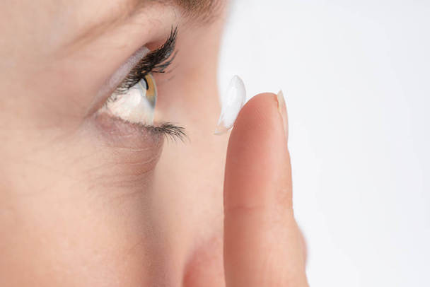 Close-up van een vrouw die een contactlens wil gebruiken - Foto, afbeelding