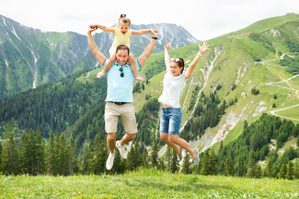 Happy Family With Little Girl Jumping In Austrian Mountains In Summer - Fotografie, Obrázek