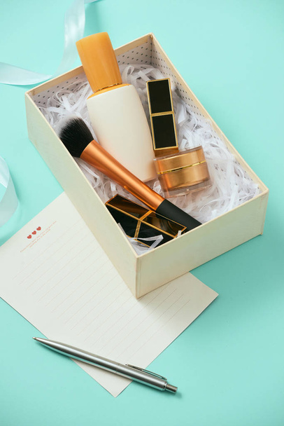 Make up gift box with serum, blush, brushes, cream and lipsticks indoors - Foto, Imagen