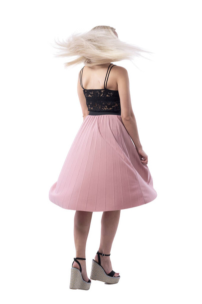 Back view of blonde young woman in summer skirt spinning and dancing with flying hair. Full body isolated on white background.  - Foto, imagen
