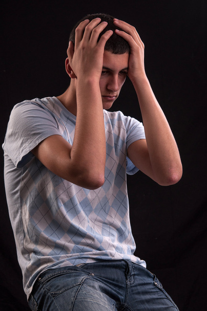 Підліток з головою в руках, що викривляються від стресу, мучиться
 - Фото, зображення