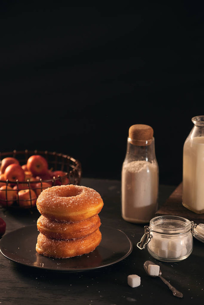 frische Donuts mit Zuckerpulver und Kaffee mit Milch auf einem Holztisch. Frühstück im Dorf.  - Foto, Bild