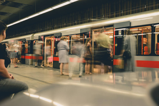 Praag, Tsjechische Republiek, 23 juli 2019; Mensen bij metrostation invoeren metro trein, lange belichtings techniek voor beweging. Stedelijke scène, stadsleven, openbaar vervoer en verkeers concept. - Foto, afbeelding