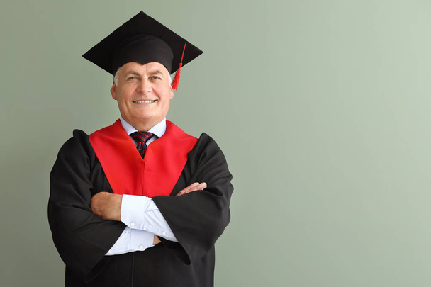 Mature man in bachelor robe on color background - Photo, Image