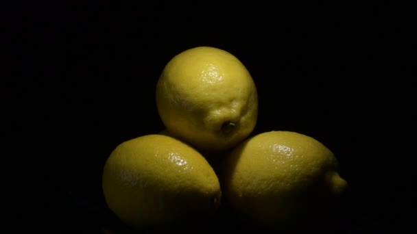 Čerstvé citrony ovoce kroužící na černém pozadí s intimním světlem - Záběry, video