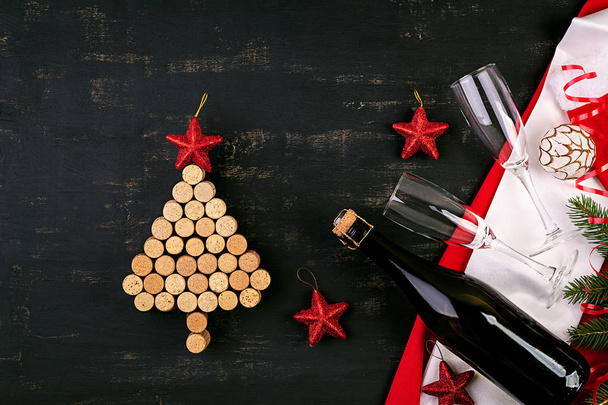 New Year decoration with christmas tree made of wine corks and bottle of champagne. Christmas background. Top view. - Фото, зображення