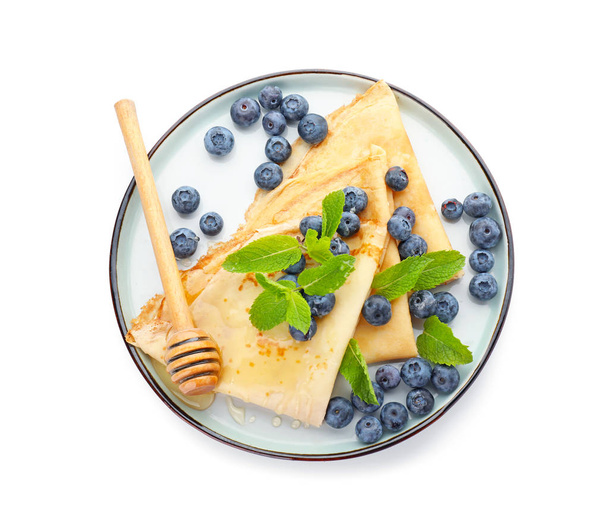 Plate with tasty blini, blueberry and honey on white background - Фото, зображення